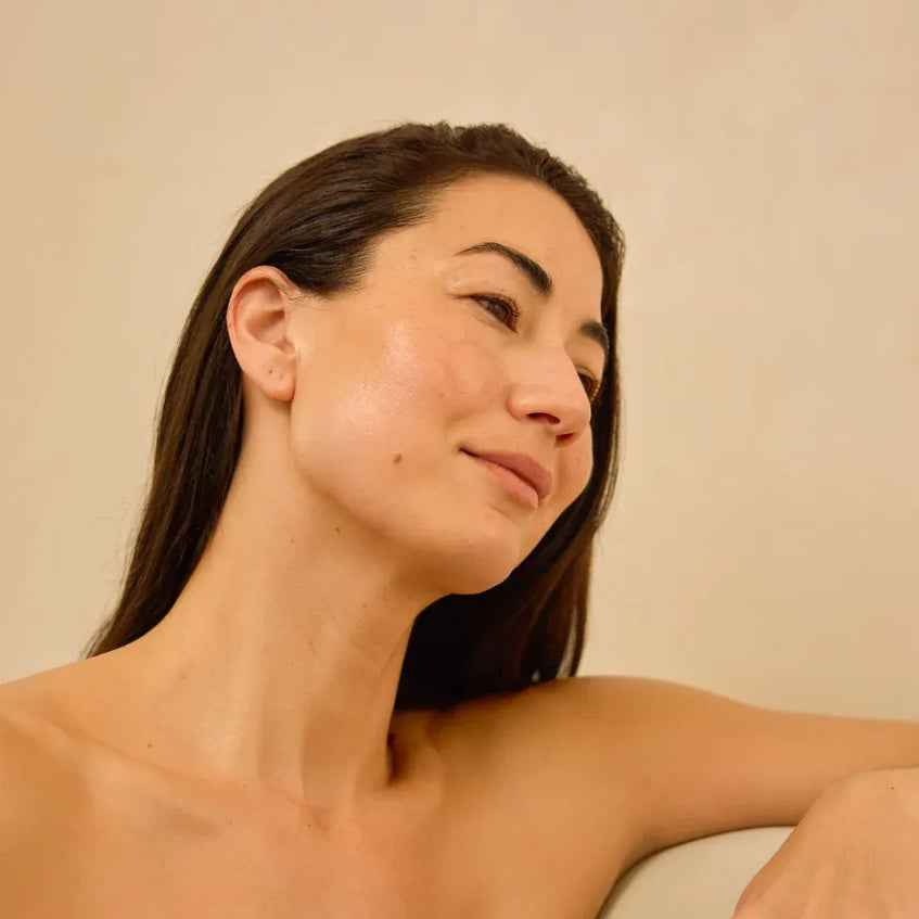 Woman with long dark hair against a beige background