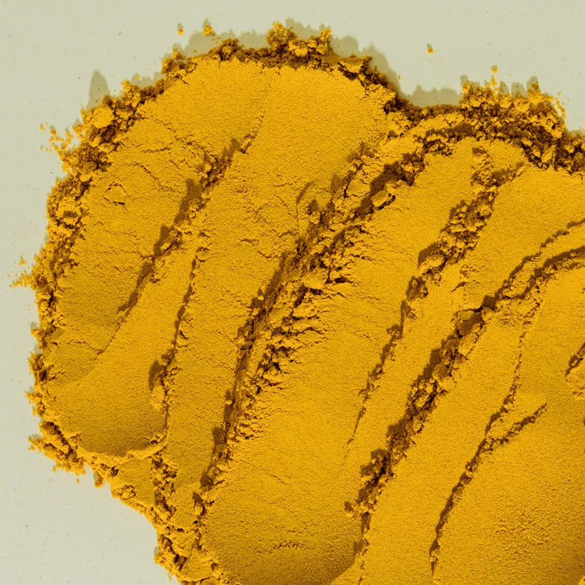 Close-up of yellow powder with texture on a light gray background