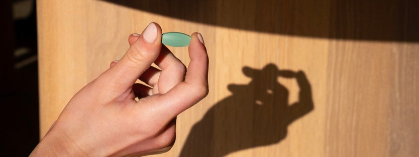 A hand holding a green tablet