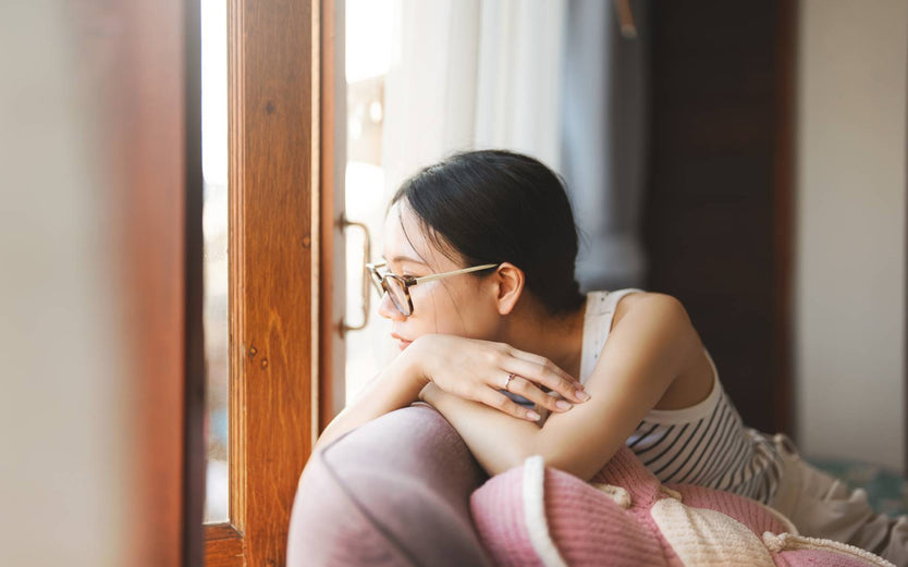 Person sitting on a couch staring out the window