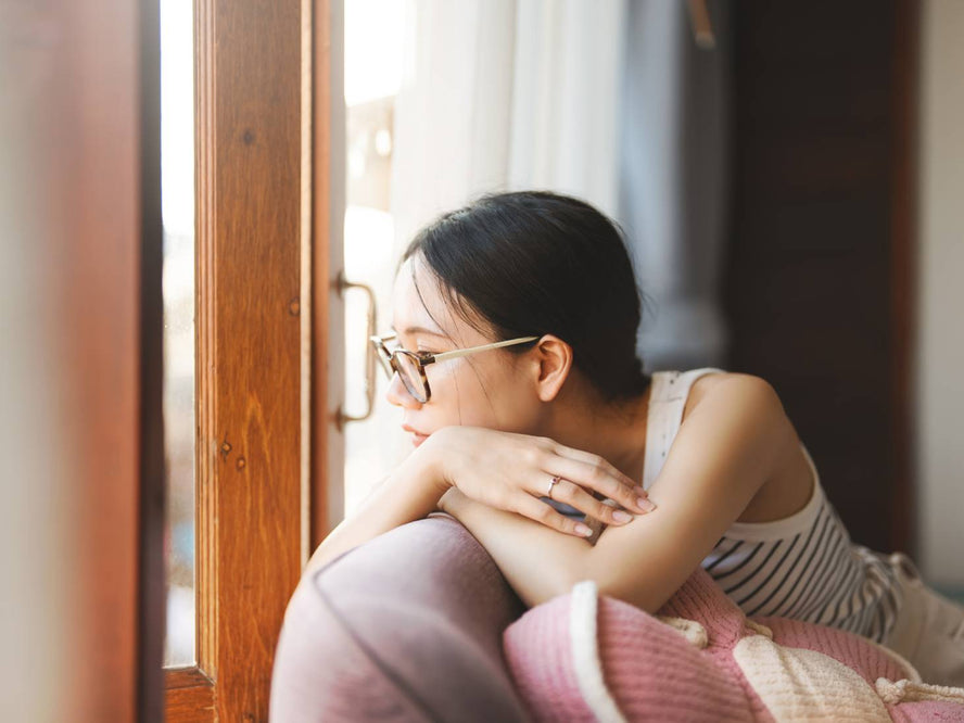 Person sitting on a couch staring out the window
