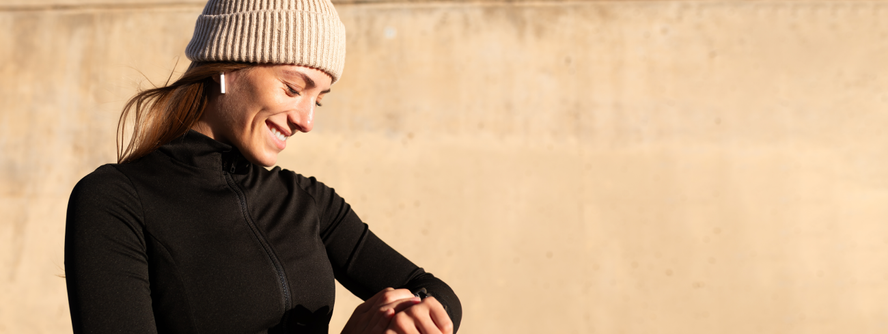 Woman checking her watch on a winter work out