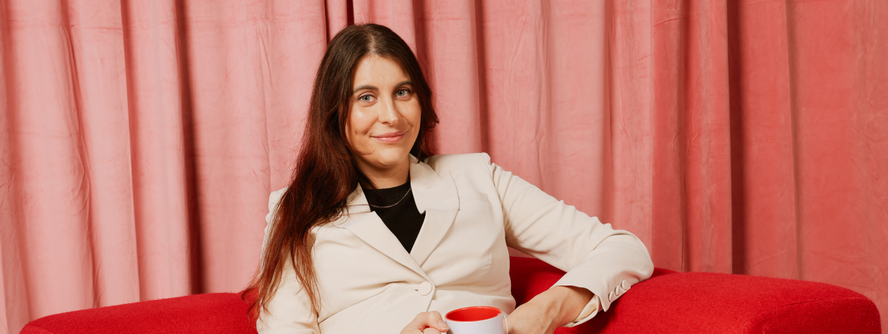 Image of Carly Dober sitting on a couch with a cup of tea