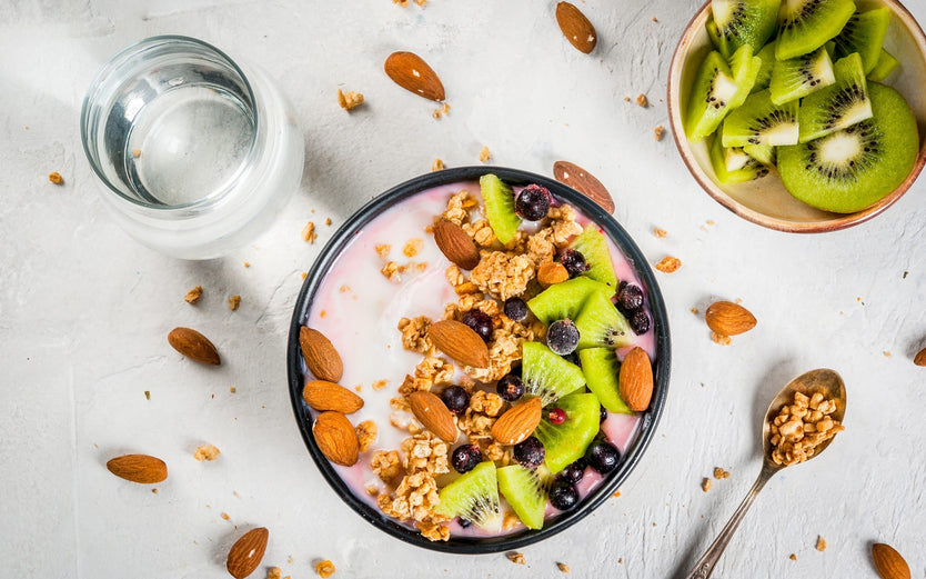 Birdseye shot of granola bowl with nuts and kiwis