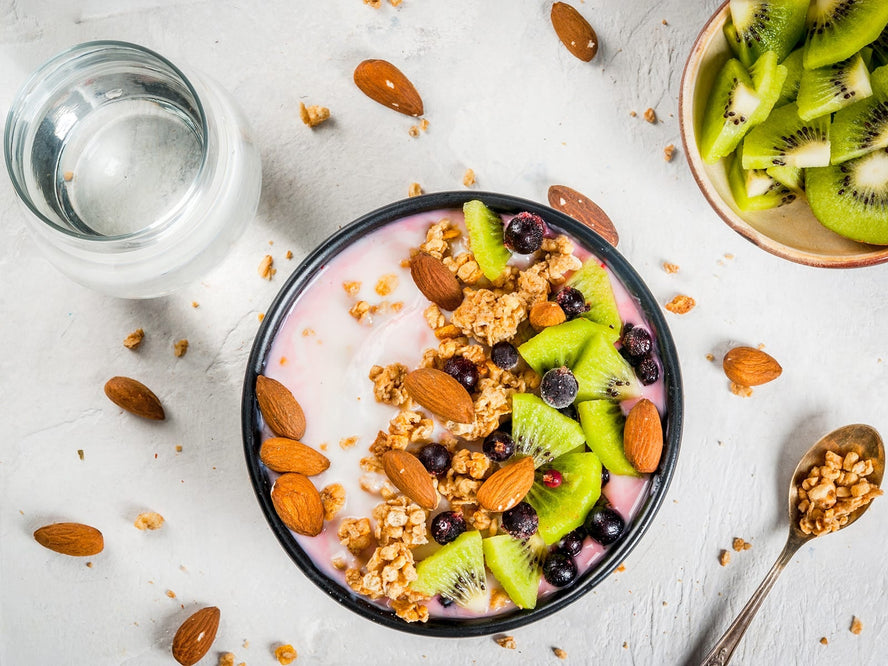 Birdseye shot of granola bowl with nuts and kiwis