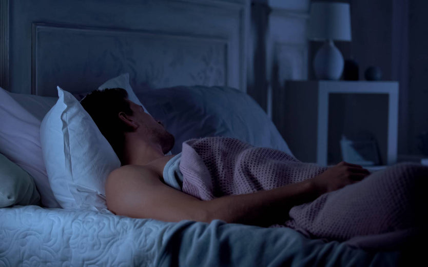 Person in bed asleep in a dark room