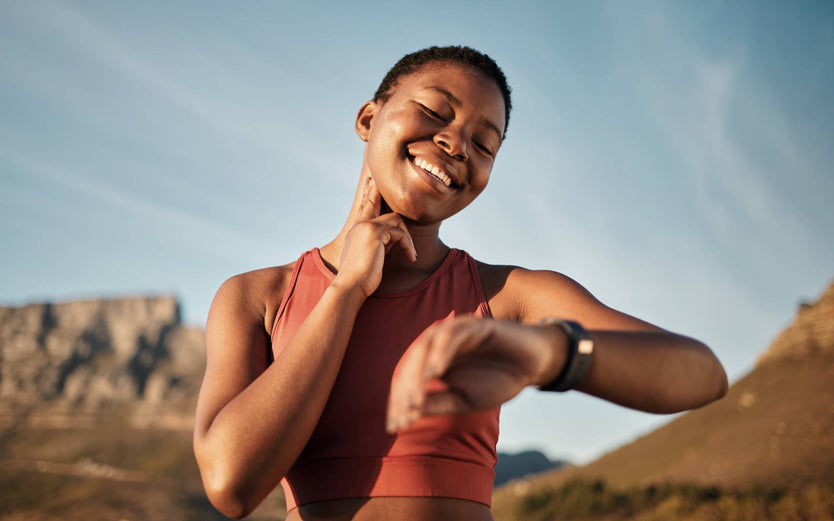 Person checking their pulse and smart watch
