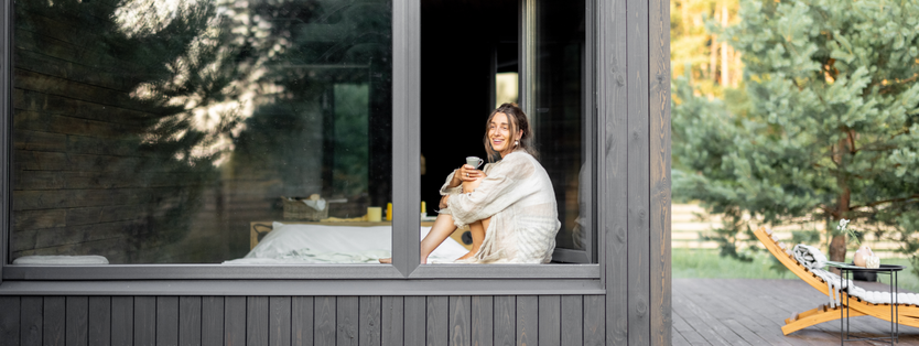 A woman sitting in a window holding a cup of tea