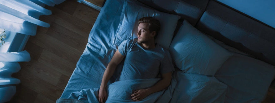 A man laying in bed asleep at night