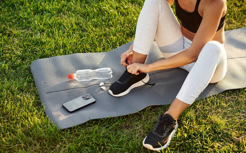 Person sitting outside on a yoga mat
