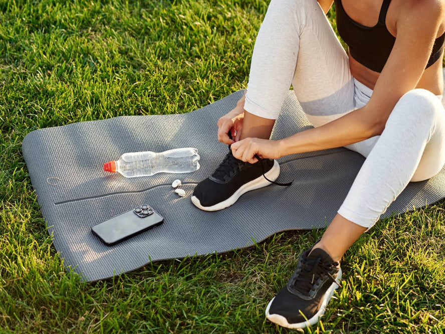 Person sitting outside on a yoga mat