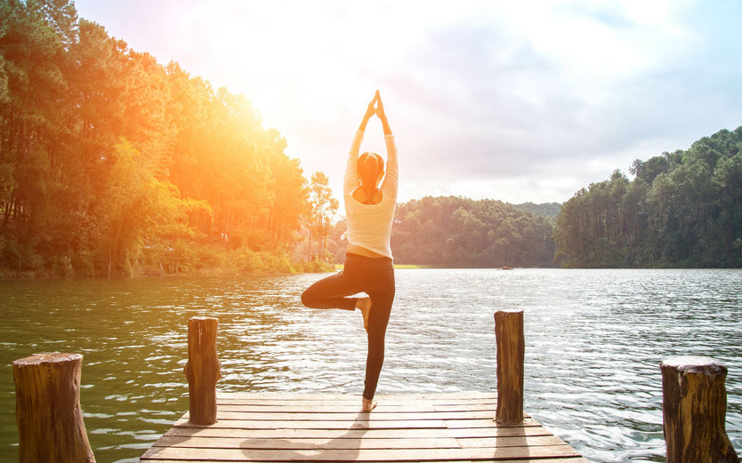 A woman doing yoga on a pier 