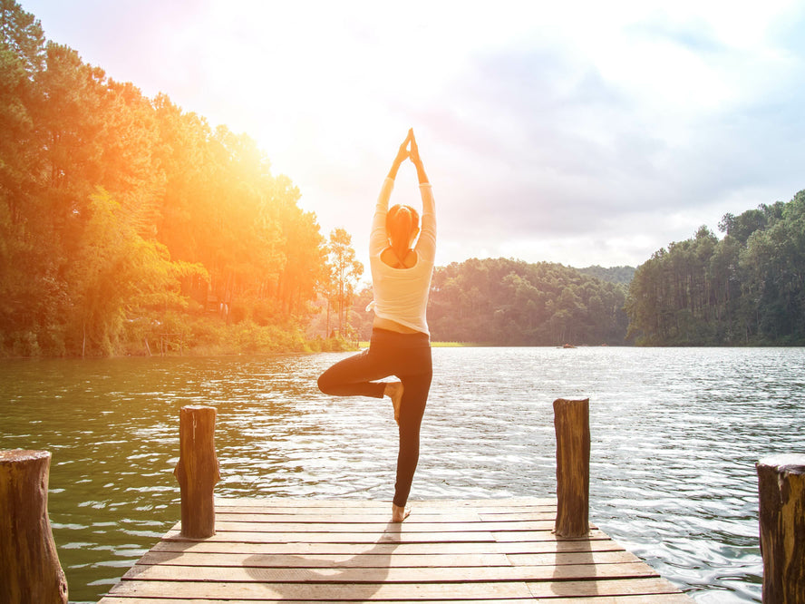 A woman doing yoga on a pier 