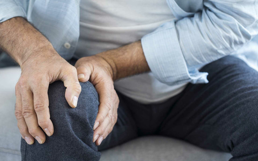 Person clutching knee in pain