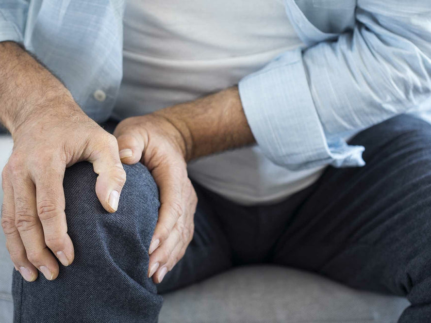 Person clutching knee in pain