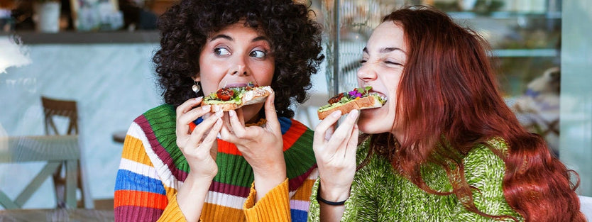 Two people eating and looking away from the camera