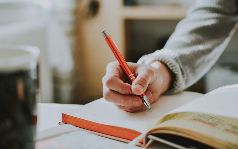 Someone writing in a book