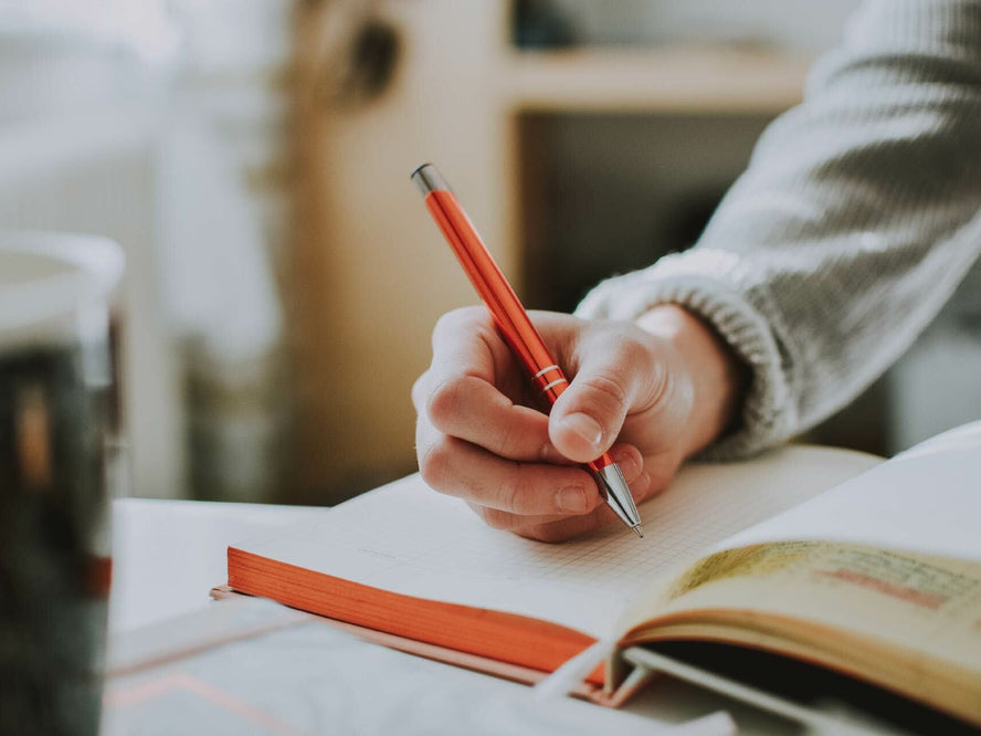 Someone writing in a book