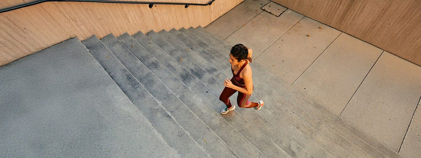 Woman running up a set of indoor stairs