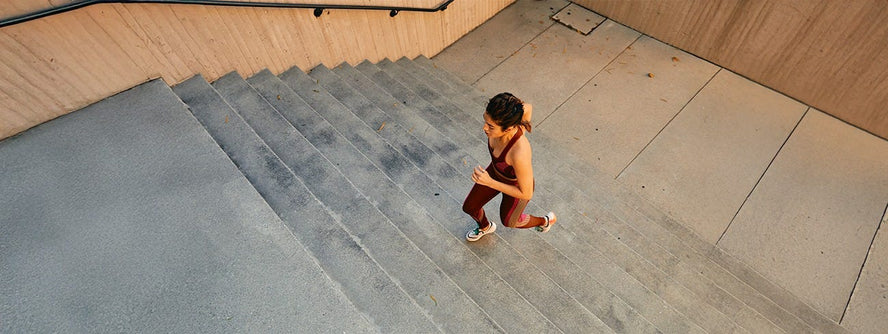 Woman running up a set of indoor stairs