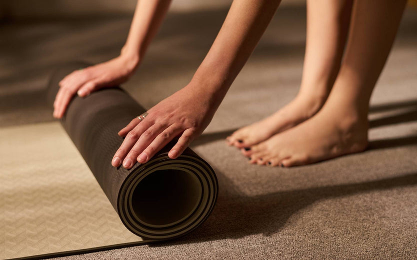 Person rolling up their yoga mat