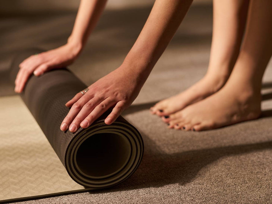 Person rolling up their yoga mat