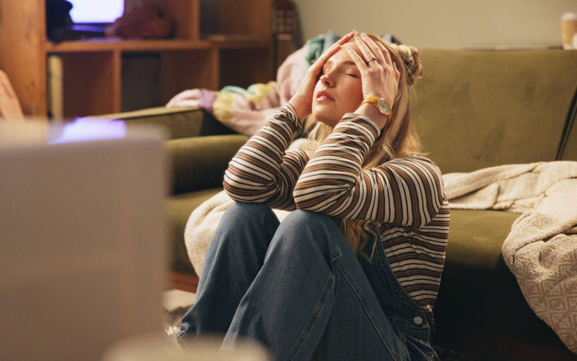 Person sitting on the floor looking stressed