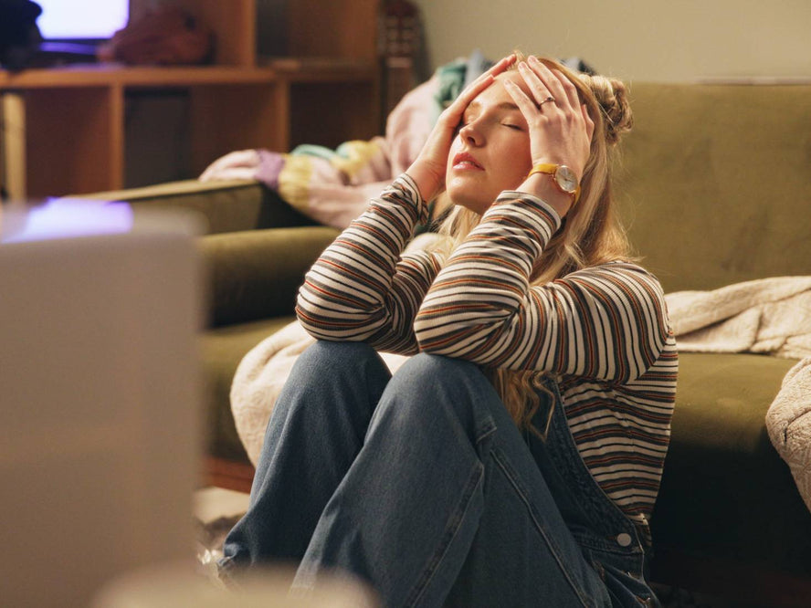 Person sitting on the floor looking stressed