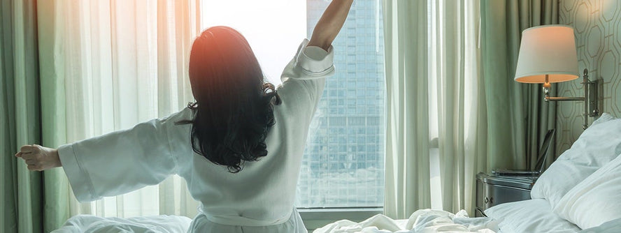 Person waking up and stretching sitting in bed