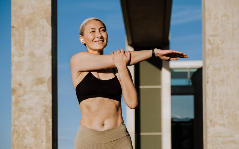 Woman stretching outside in activewear 