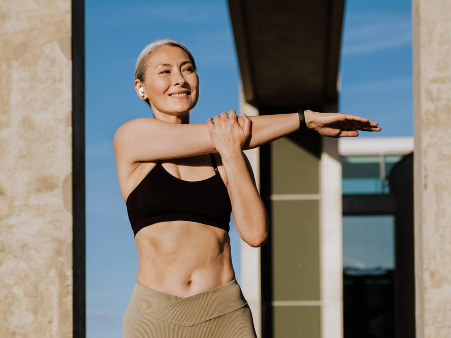 Woman stretching outside in activewear 