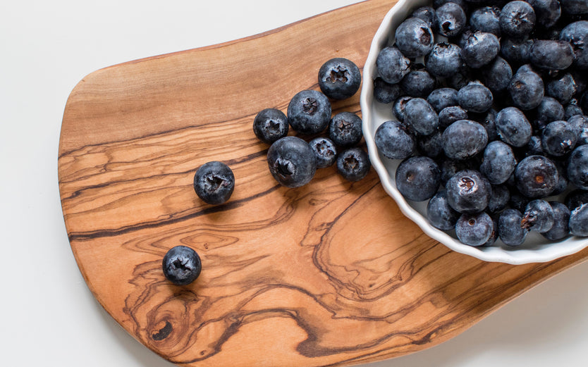 Bowl of blueberries on a wooden board