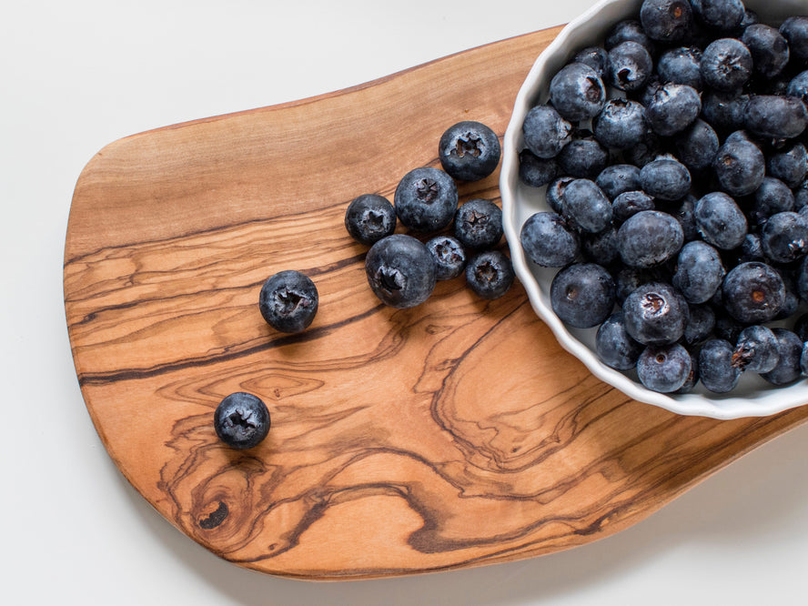 Bowl of blueberries on a wooden board