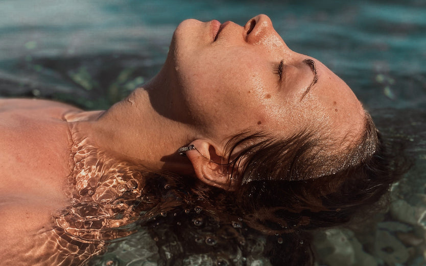 Profile of a woman's head leaning back into water