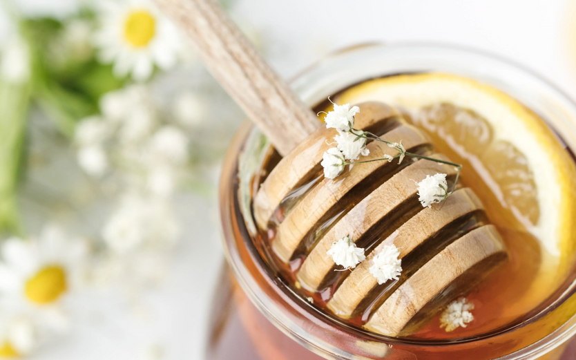 A jar of manuka honey with a lemon slice