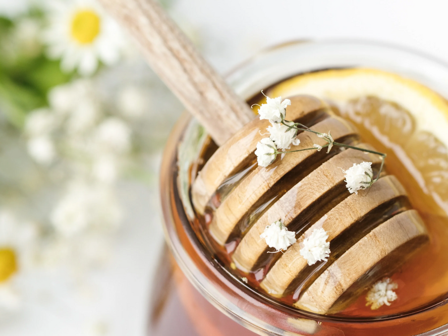 A jar of manuka honey with a lemon slice