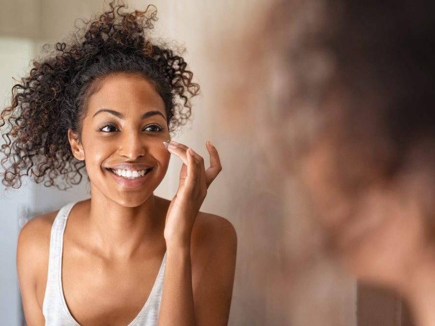 Picture of woman doing skincare in mirror
