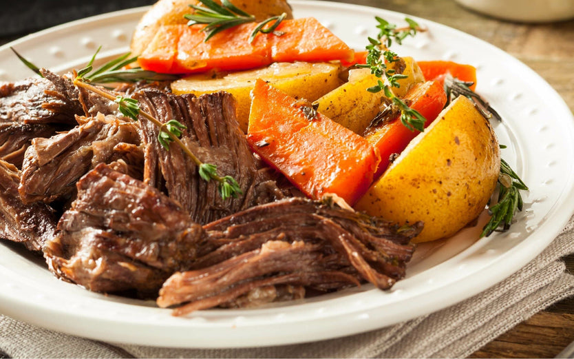 Slow cooked roast beef on a plate with potatos and carrots
