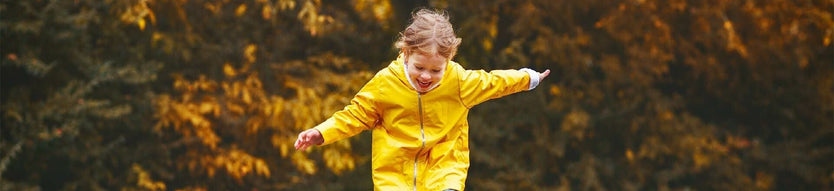 Child running outside in rain coat