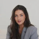 Woman in a gray blazer against a white background