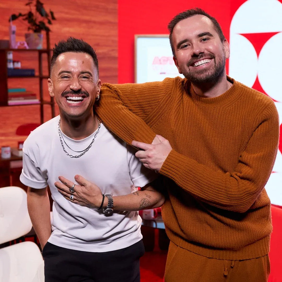 Two men smiling and posing for a photo in front of a red background with a Target logo.