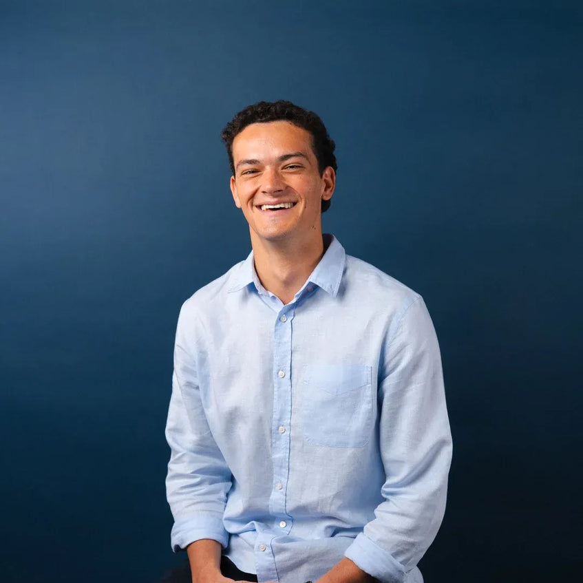 Man wearing a light blue shirt against a dark blue background