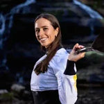 Woman holding a kayak with a blurred natural background