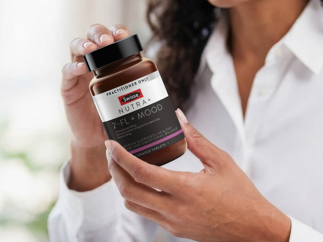 Person holding a Swisse Nutra+ Mood supplement bottle
