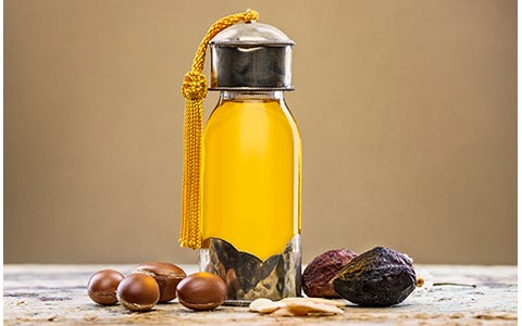 Clear glass bottle of golden argan oil