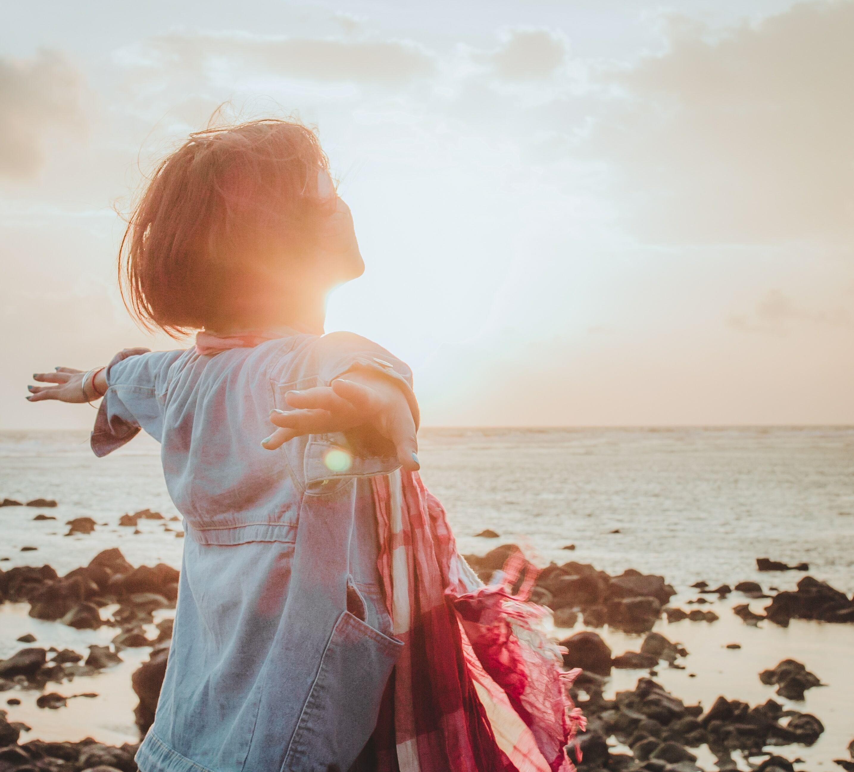 Happy woman on a beach at sunset