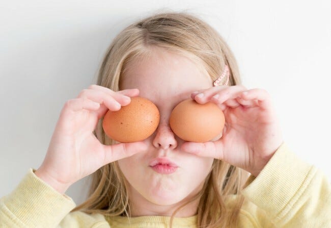 Little girl holding two eggs