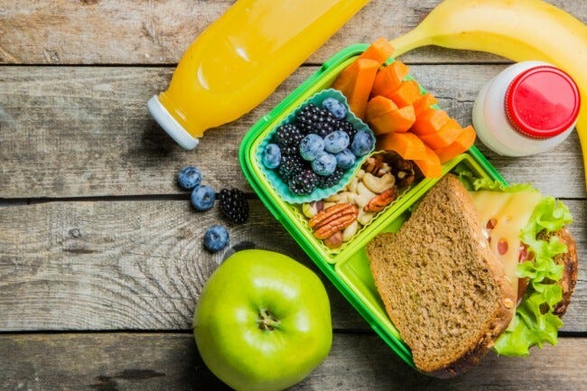 Lunchbox with a sandwich, fruit and juice
