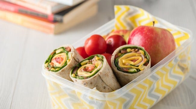 Lunchbox with wraps, an apple and cherry tomatoes