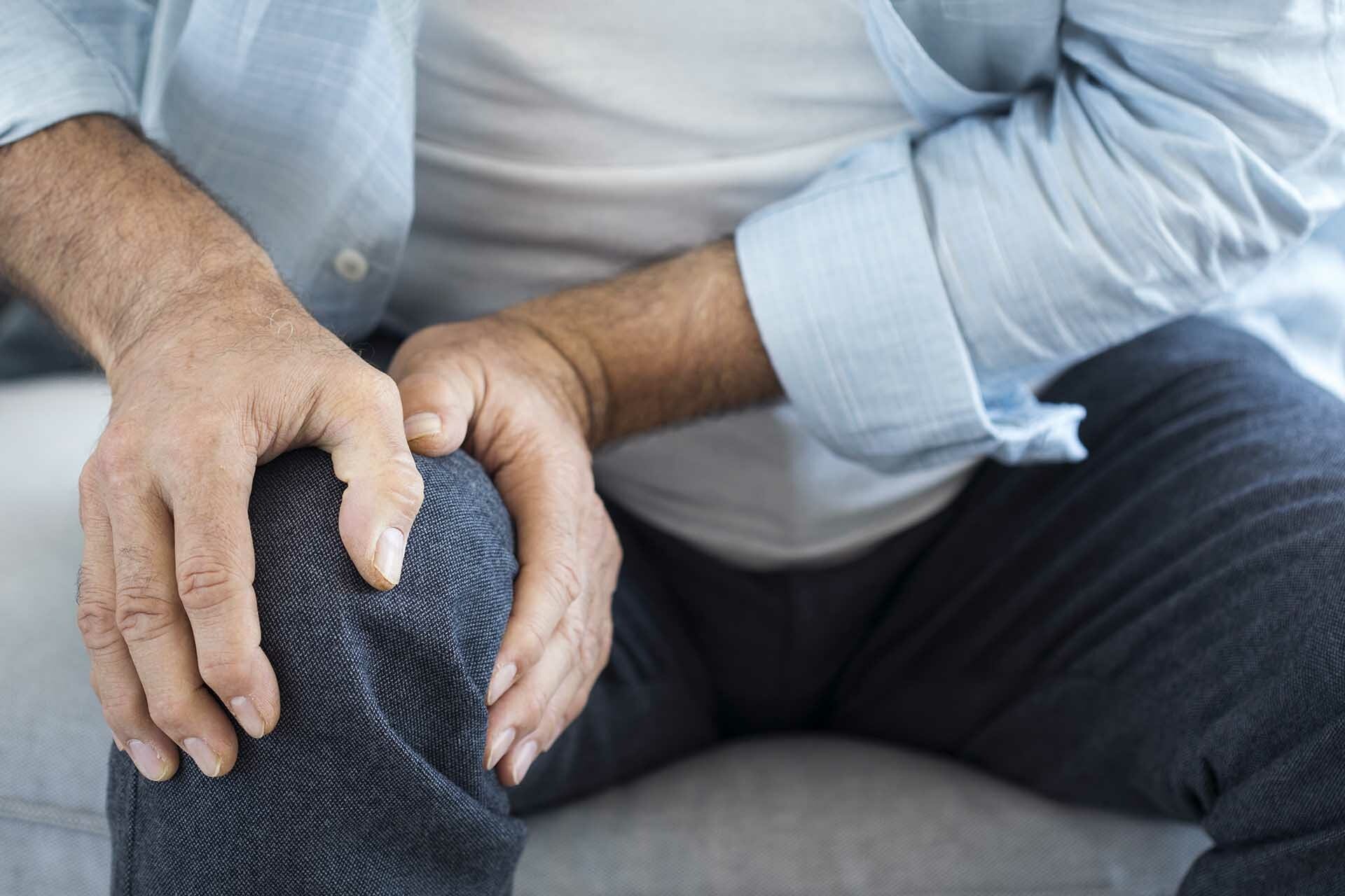 Person clutching knee in pain